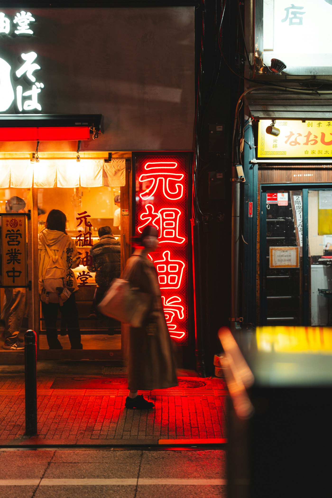 Rua de Tóquio à noite com letreiros de neon disputando atenção